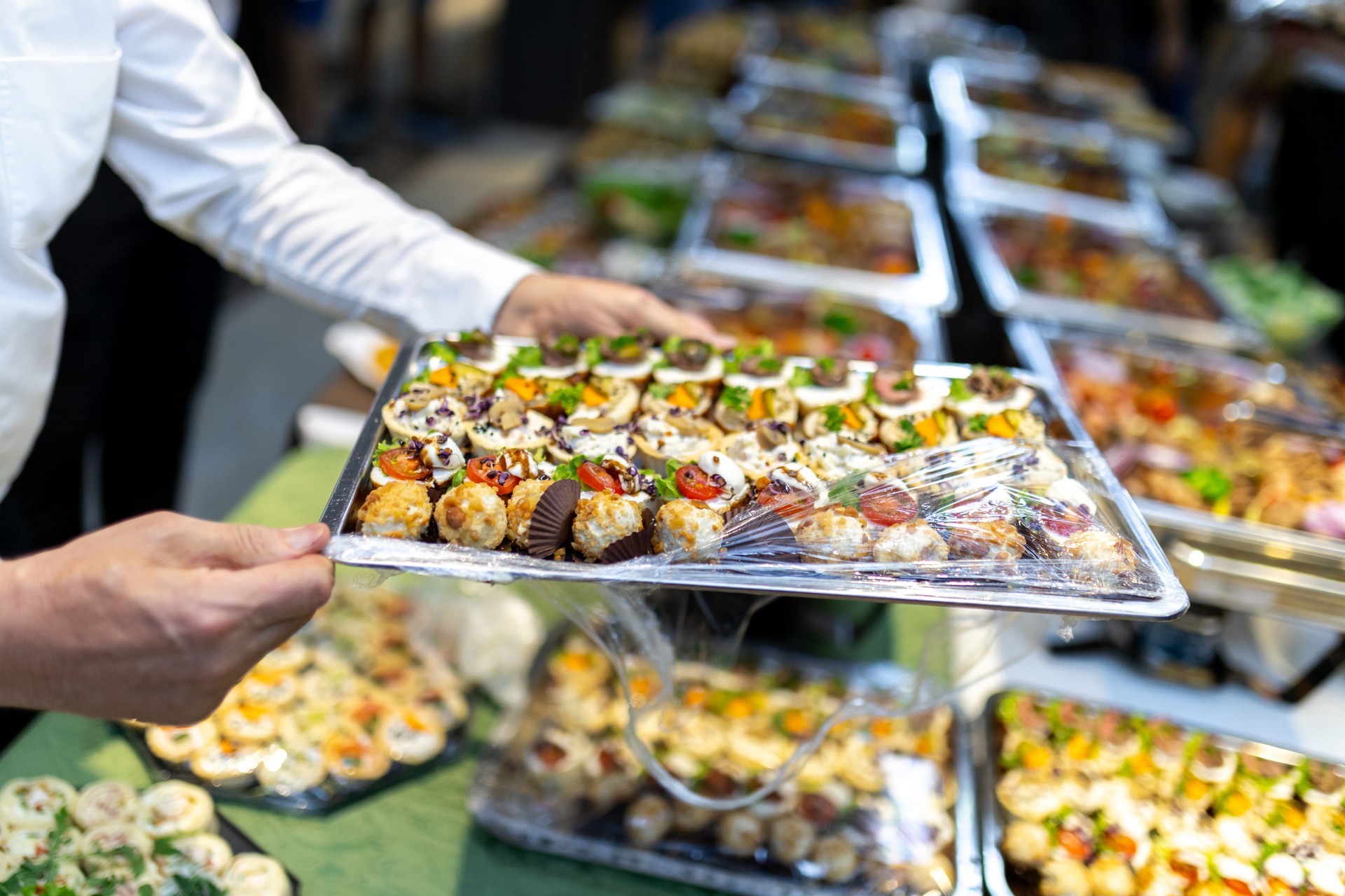 Catering service presents elegantly arranged hors d'oeuvres at a formal evening event in a banquet hall setting