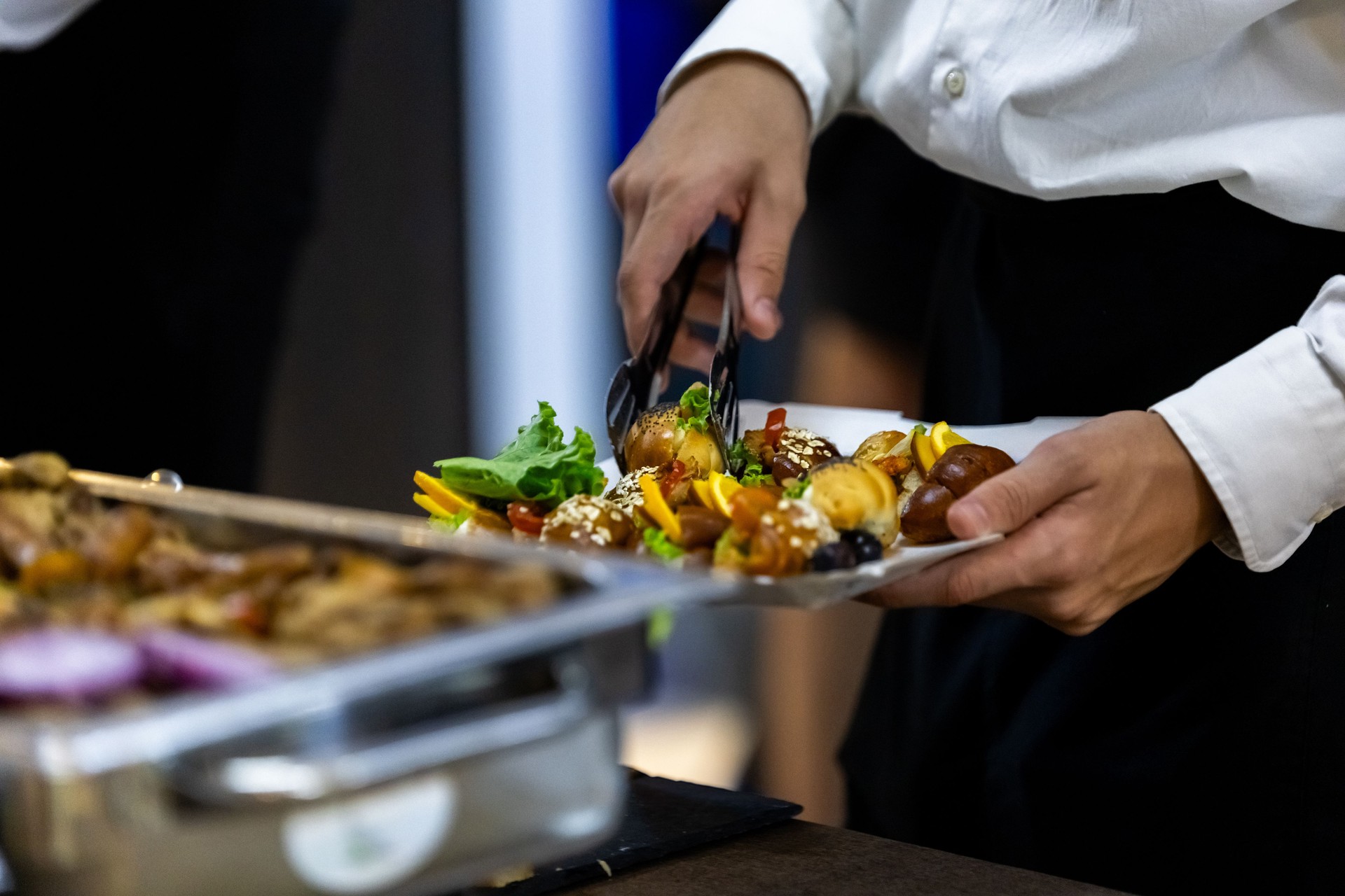 Catering service providing a gourmet platter with fresh vegetables and appetizers at a corporate event in the afternoon